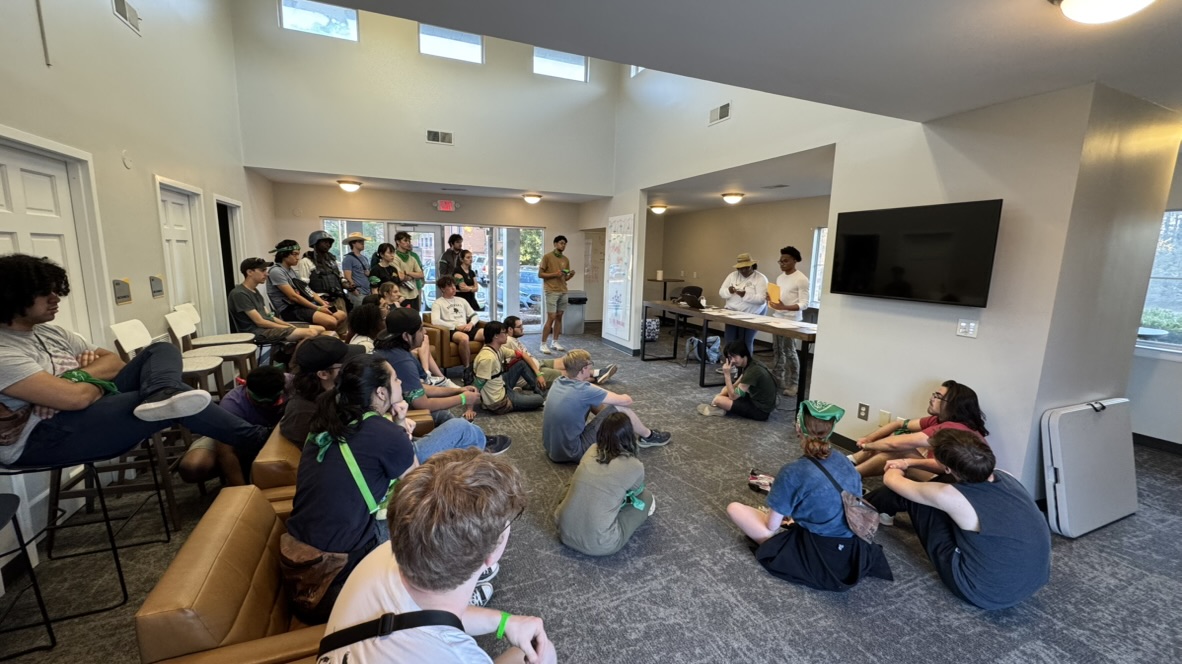 Players seated in a room during a game briefing